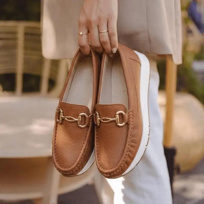Mocasín de cuero marrón mujer con suela blanca antiderrapante y adorno metálico dorado para comodidad y estilo casual