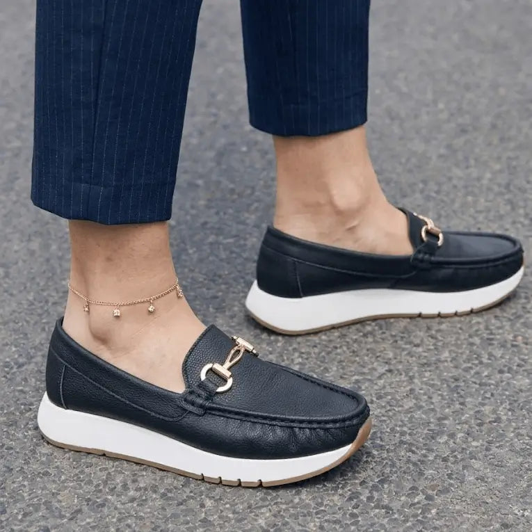 Mocasín casual para mujer Bolichero Maíra en color negro con suela blanca de goma, detalle metálico dorado, cuero suave y plantilla acolchonada antideslizante, ideal para uso diario con confort y estilo urbano.