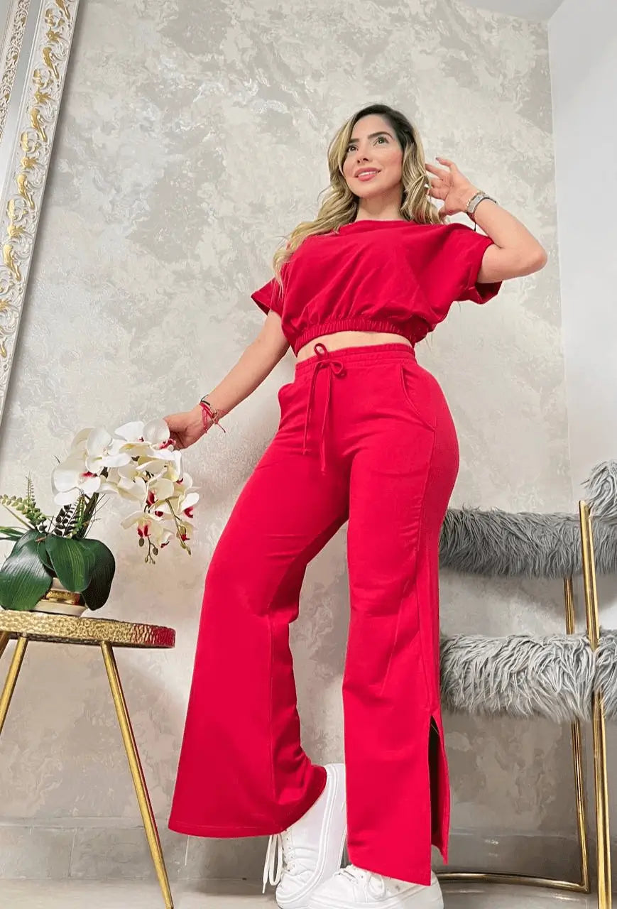 Conjunto bota campana rojo con top crop de manga corta y pantalón acampanado con tajos laterales, combinado con tenis blancos, tejido suave y elástico que realza la figura y ofrece comodidad y estilo casual
