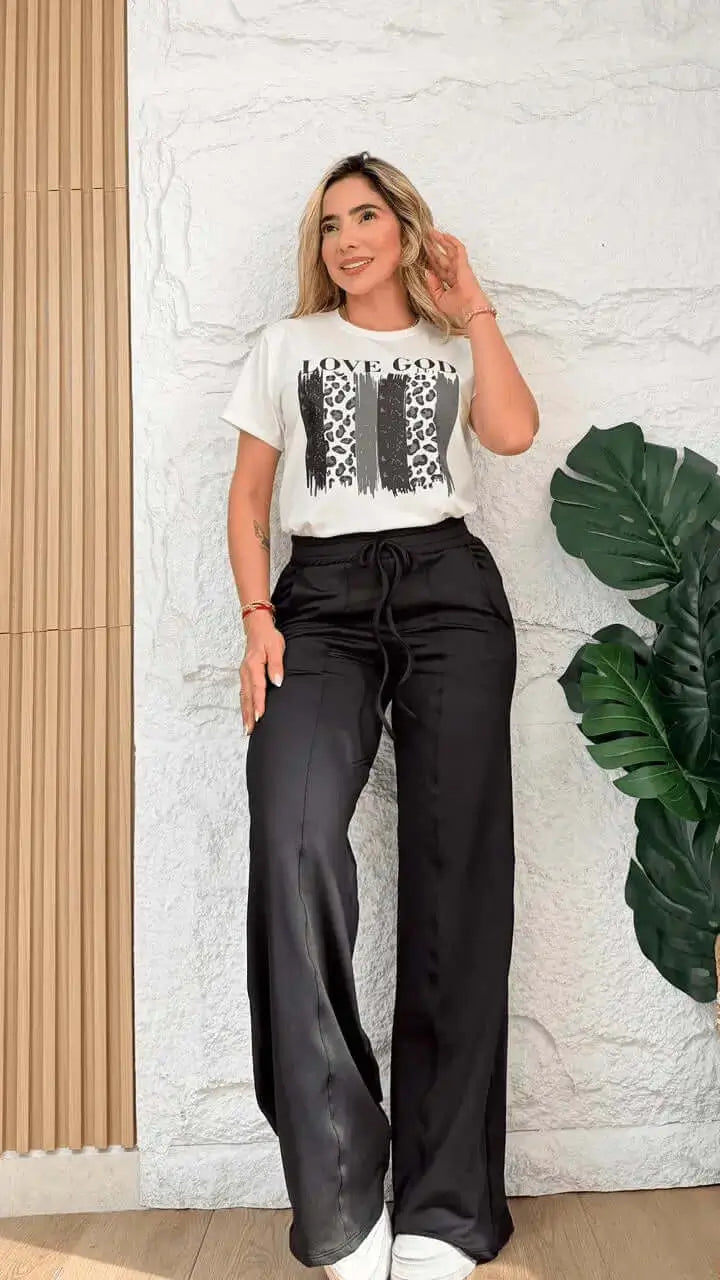 Conjunto Love Good para mujer con camiseta blanca de algodón y estampado animal print y pantalón negro holgado de tela fluida con cintura ajustable, estilo casual elegante e ideal para máxima comodidad diaria con zapatillas blancas.