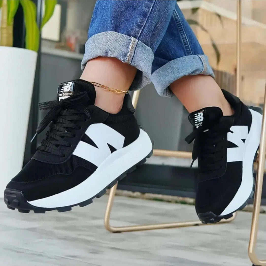 Zapatillas negras y blancas estilo casual para mujer, diseño moderno y cómodo con suela antideslizante, ideales para uso diario y ejercicio, fabricadas con materiales respirables que ofrecen soporte y durabilidad.