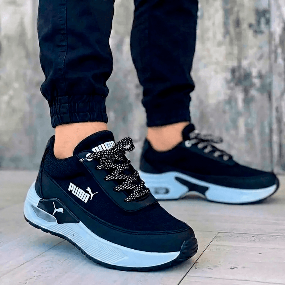 Tenis deportivos Puma para hombre negros. Diseño casual y moderno con suela plataforma blanca y amortiguación para el día a día.