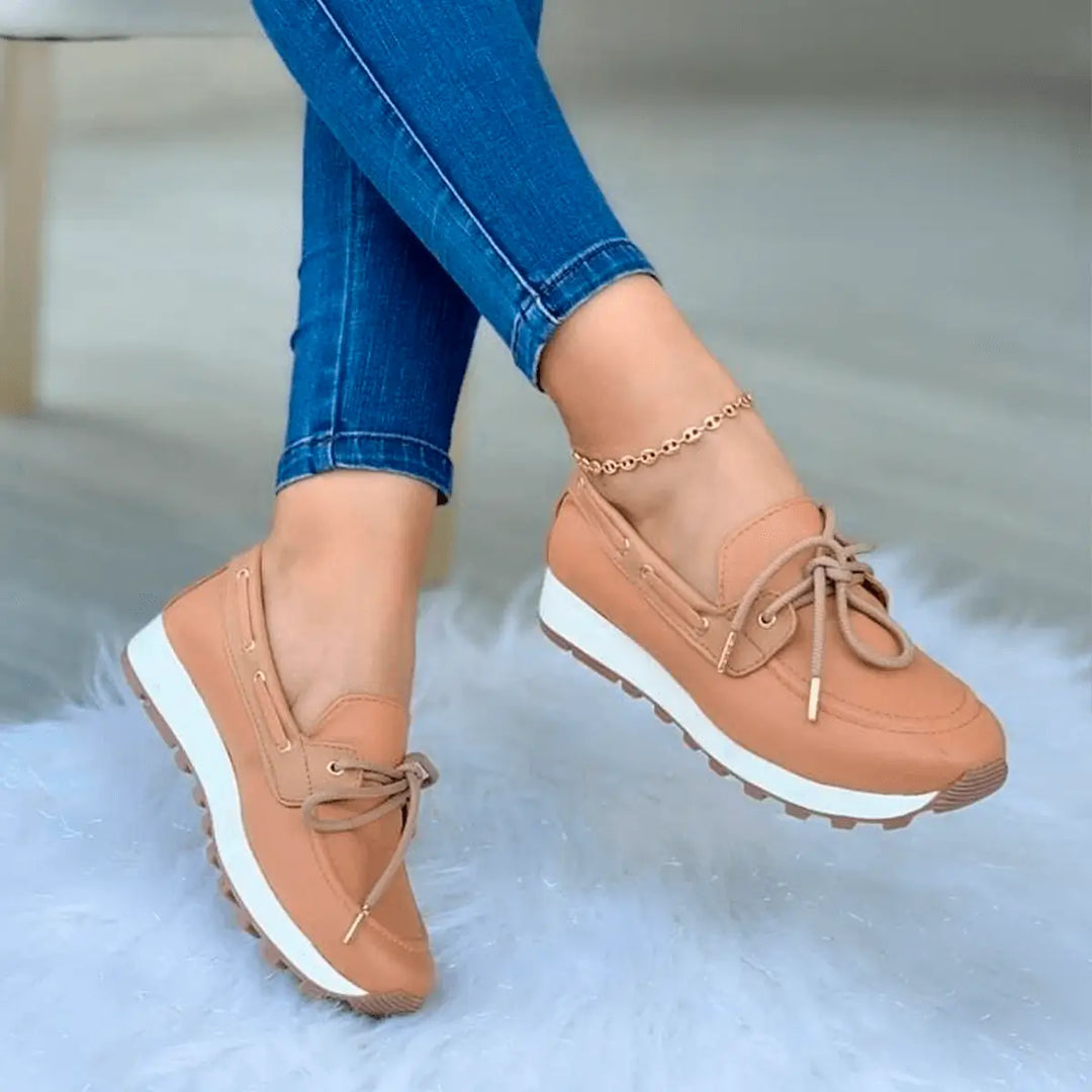 Zapatos casuales para mujer en color nude con suela blanca antiderrapante y diseño cómodo, ideales para uso diario, que combinan con jeans ajustados para un estilo moderno y elegante, ofreciendo soporte y confort durante todo el día.