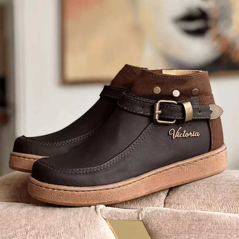 Botín femenino en cuero sintético y gamuza color café oscuro, diseño elegante con hebilla ajustable, suela antideslizante y cómoda ideal para uso diario y clima frío, calzado duradero y moderno para complementar tu look casual y profesional.