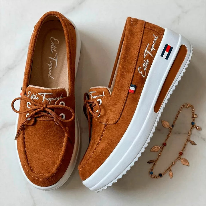 Vista superior del par de Zapatillas Francia color Miel, mostrando plantillas con logo Estilo Tropical, diseño tipo mocasín y cordones frontales sobre superficie de mármol.