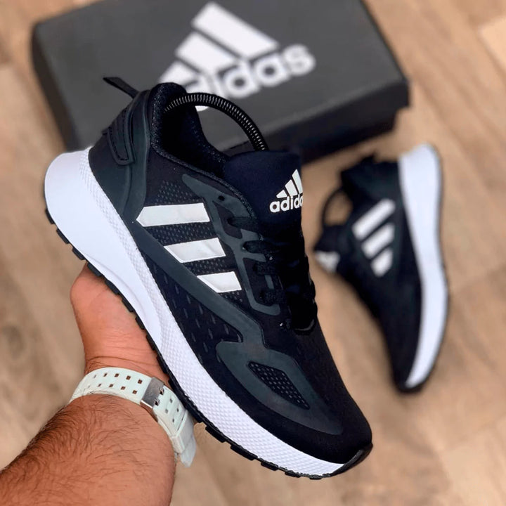 Tenis deportivos negros con detalles blancos, diseño moderno y versátil para correr o usar a diario.