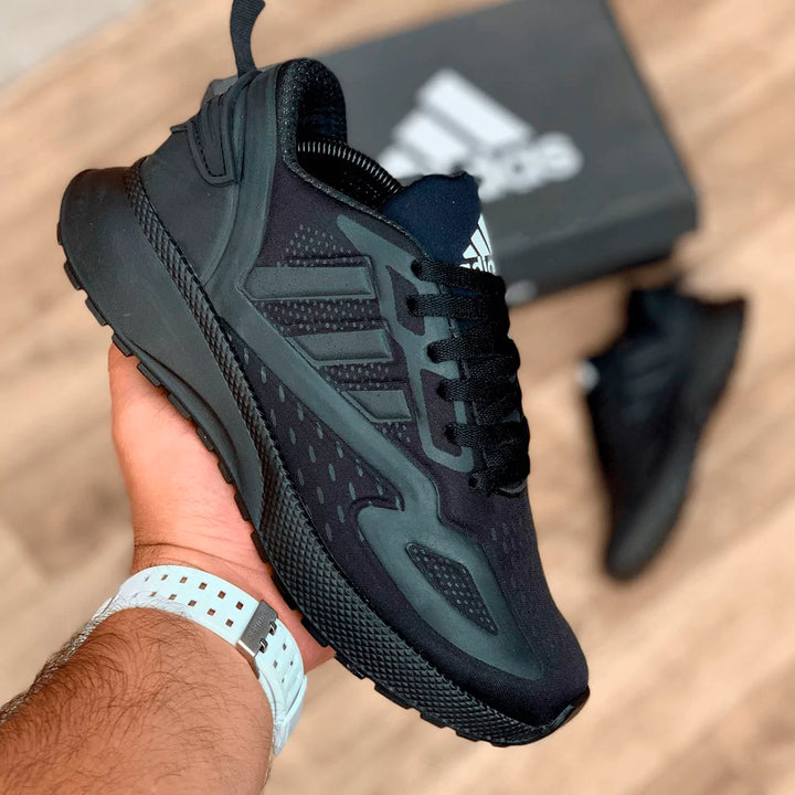 Tenis totalmente negros con suela gruesa, diseño deportivo ideal para alto rendimiento y uso urbano.