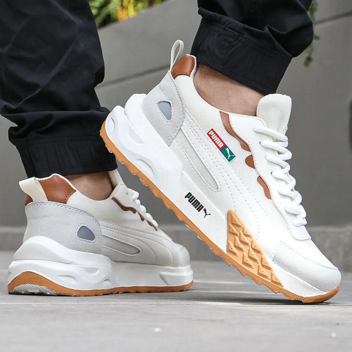 Zapatillas deportivas urbanas blancas con detalles en marrón y suela de goma antiderrapante, diseño cómodo y ligero ideal para uso diario, estilo moderno y versátil para combinar con ropa casual, calzado transpirable y con amortiguación superior para máximo confort al caminar.